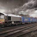 Class 66 locomotive hauling a train of Russell containers under a leaden sky