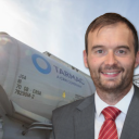 portrait of Chris Swan of Tarmac with cement rail truck in background