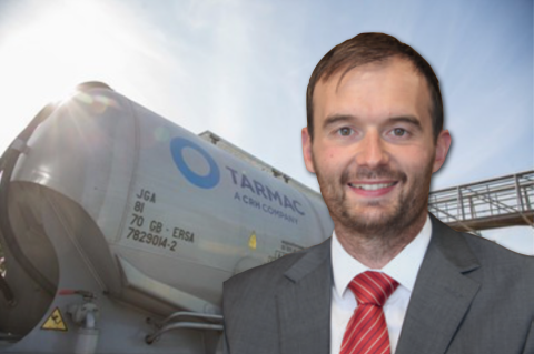 portrait of Chris Swan of Tarmac with cement rail truck in background