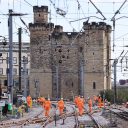 looking down the tracks at the castle in Newcastle with engineers on the line