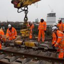 Engineers in orange suits install rails at Reading