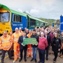 A party of about twenty people at Tunstead Quarry pose in front of several freight locomotives