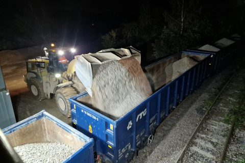 At night a huge mechanical shovel discharges a load into an open wagon