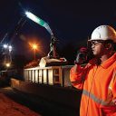 Nighttime shot of a supervisor on a walkie talkie directing an aggregates train into a terminal