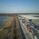 Drone shot of iPort Rail at Doncaster looking down the tracks at a departing intermodal train, The reservoirs are on the left, and warehouses on the right