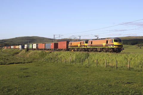 Freightliner double headed electric locomotives hauling intermodal train in countryside